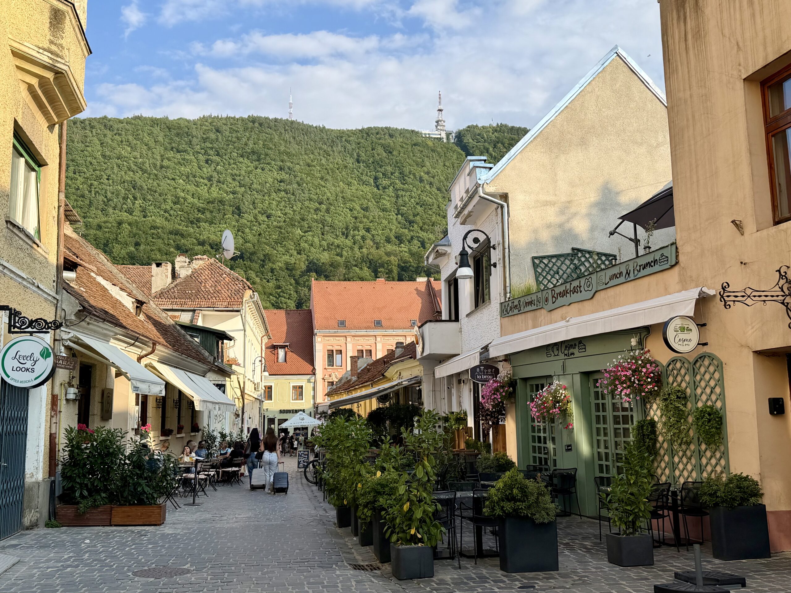 Que voir et que faire à Brașov ? Guide complet & Conseils Vue sur une rue adjacente à la Strada Republicii à Brasov avec le mont tampa en toile de fond